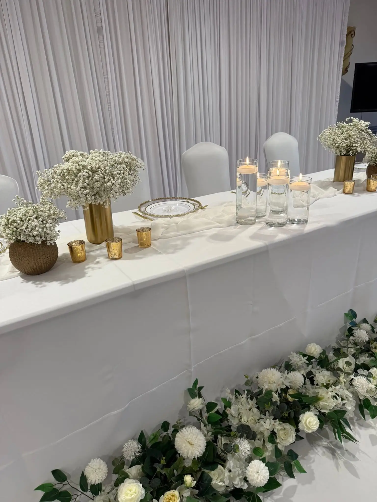 White and gold head table with baby's breath and floating candles — party decorations in Evanston, IL