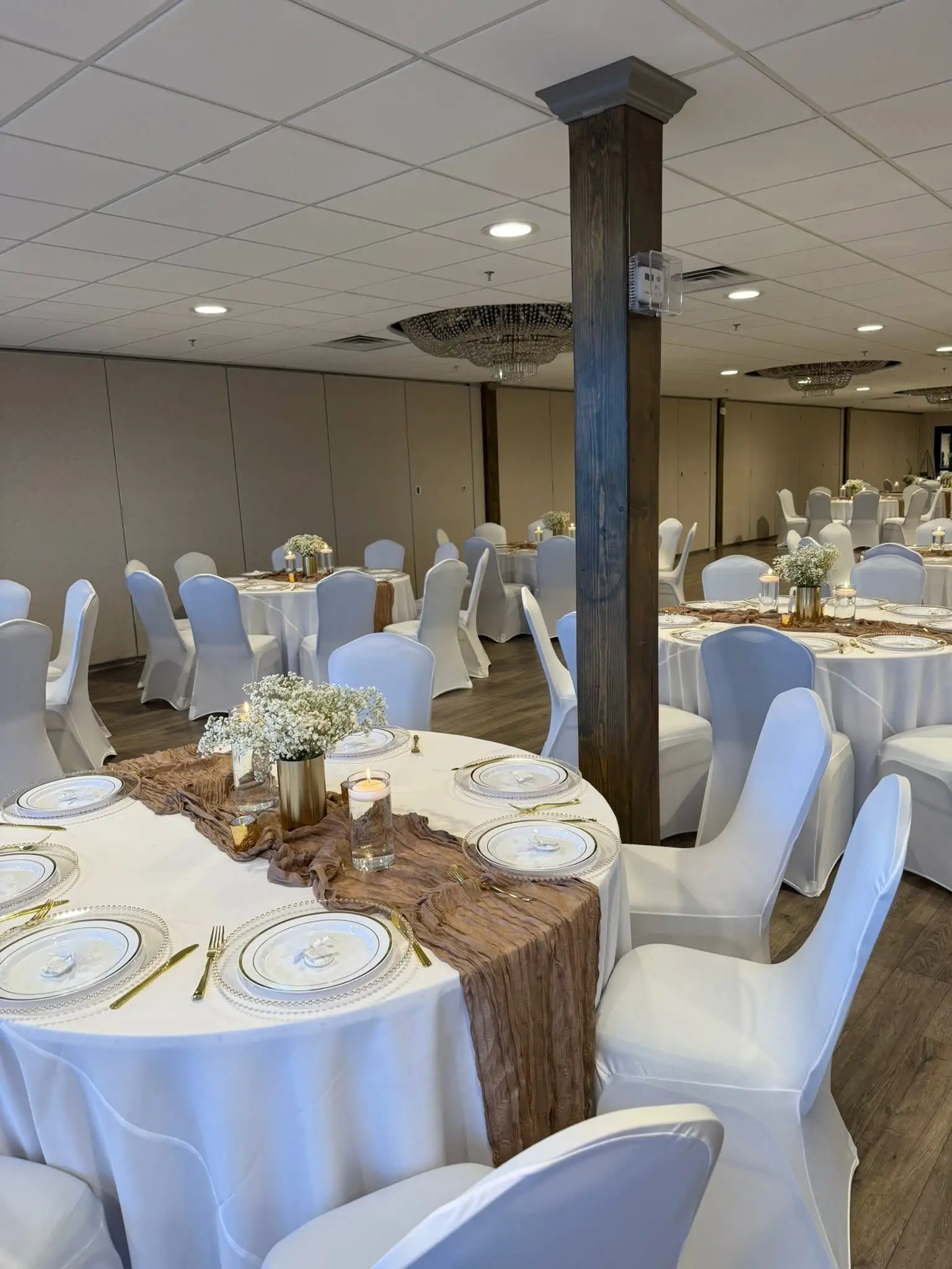 Reception table with gold chargers and rust runner under chandeliers — party decorations in Elmhurst, IL