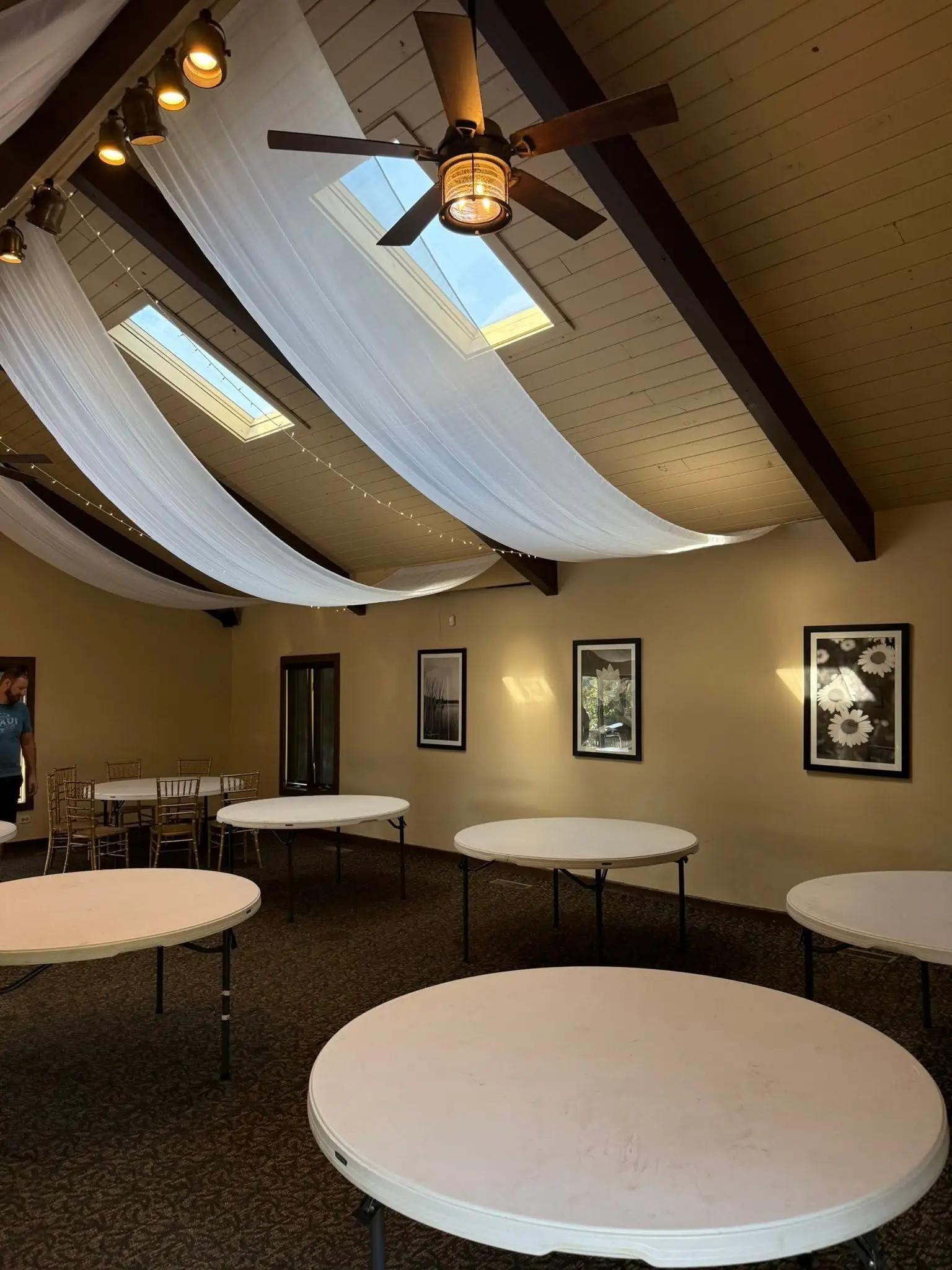 Reception room with ceiling draping, warm string lights, and round guest tables for an elegant Chicago event