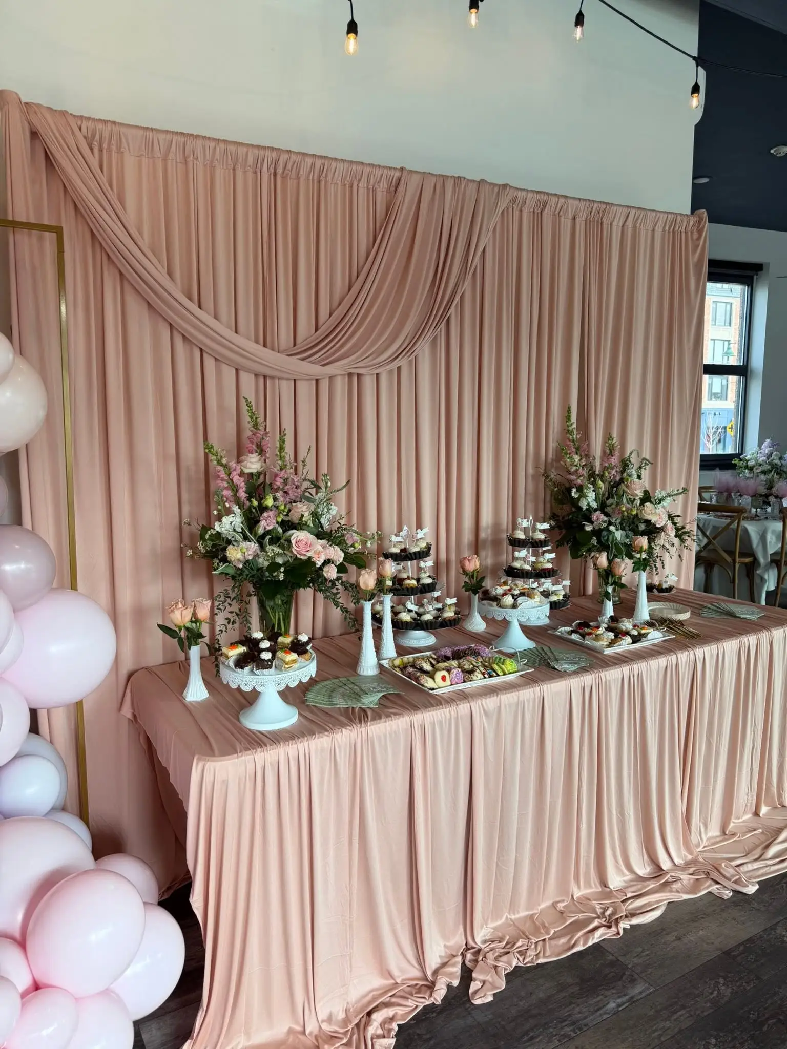 Blush bridal shower dessert table styling with florals, draping and balloon details in Chicago